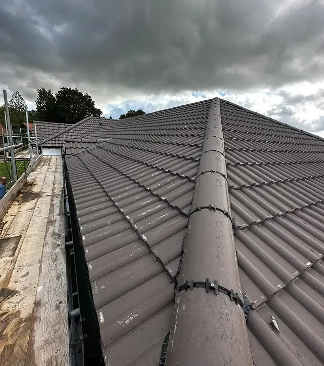 Red brick chimney repair on a residential roof