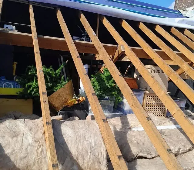 Black guttering and downpipe system on a brick house